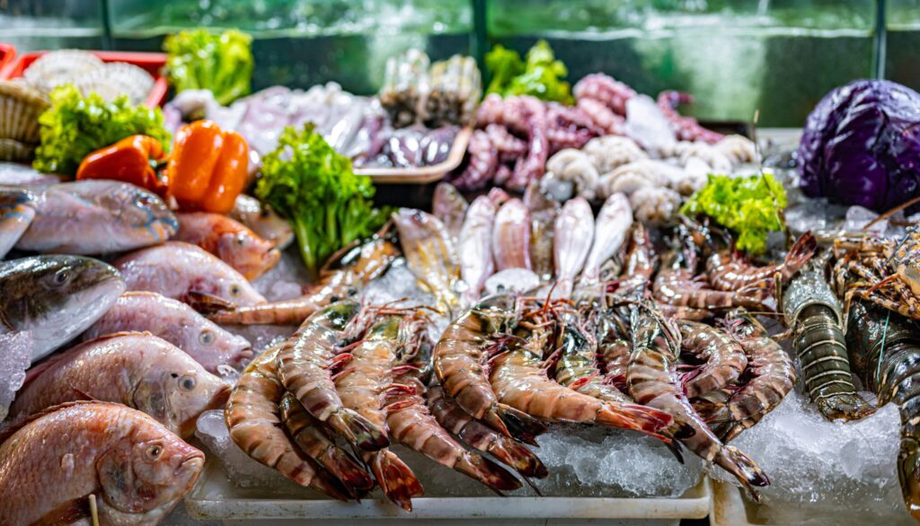 Fresh seafood display at Hua Hin Night Market with fish, prawns, and vegetables