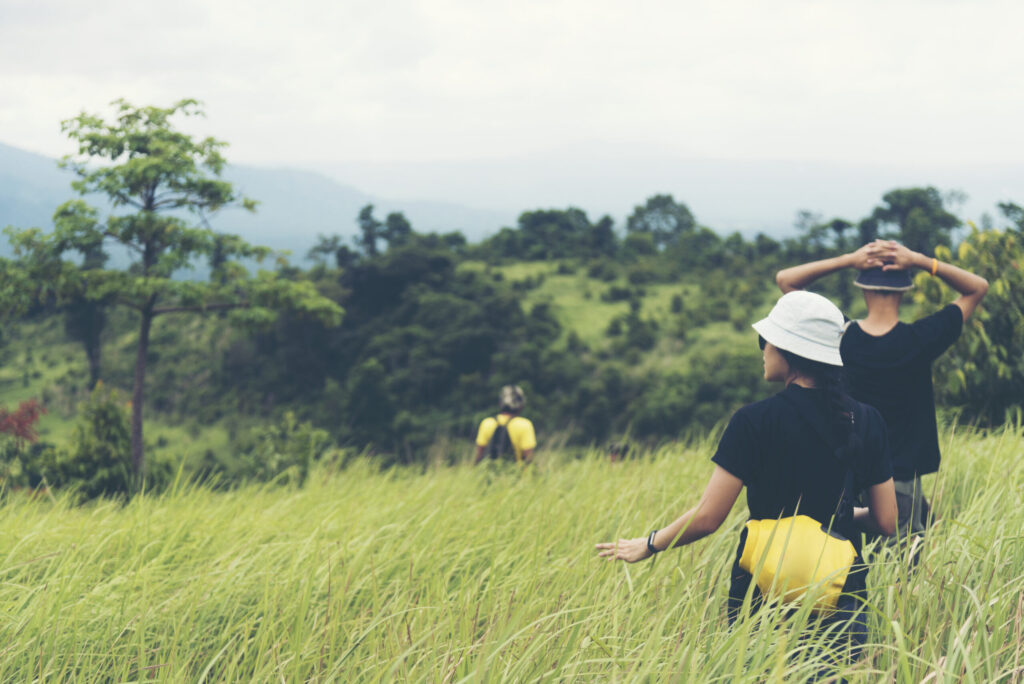 Mangrove Reforestation Project: 5 Essential Learning Outcomes for School Groups 2 students walking through tall grass on an environmental field trip connected to the mangrove reforestation project